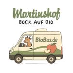 KI generiert: Das Bild zeigt den Kopf einer neugierig wirkenden Ziege, die zwischen Holzlatten hervorschaut. Auf dem Bild ist der Text "Hallo Du!" zu sehen.