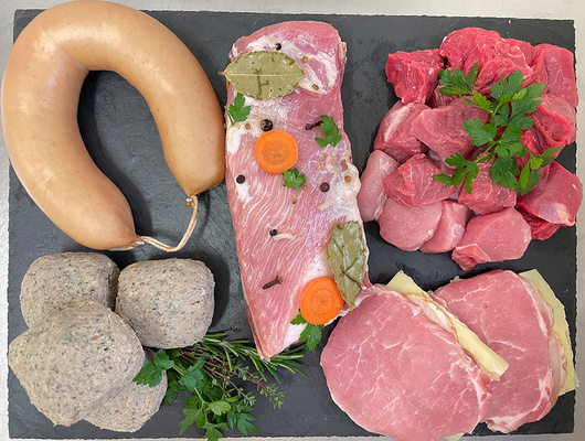 KI generiert: Verschiedene Fleischsorten auf einer Schieferplatte angerichtet mit Kräutern.