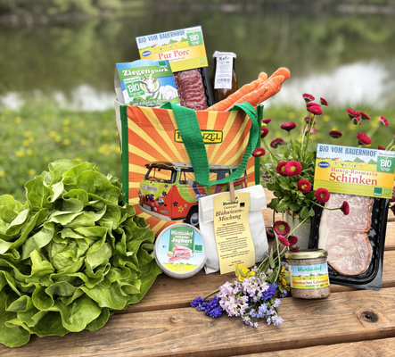 KI generiert: Bio-Lebensmittel und Blumen auf einem Holztisch im Freien. Enthält "Blühwiesen-Mischung".