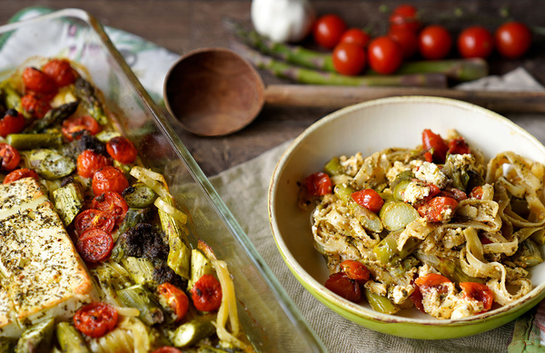 KI generiert: Eine Schale mit Pasta, Spargel, Tomaten und Feta-Käse. Hintergrund: Kirschtomaten und Spargel.