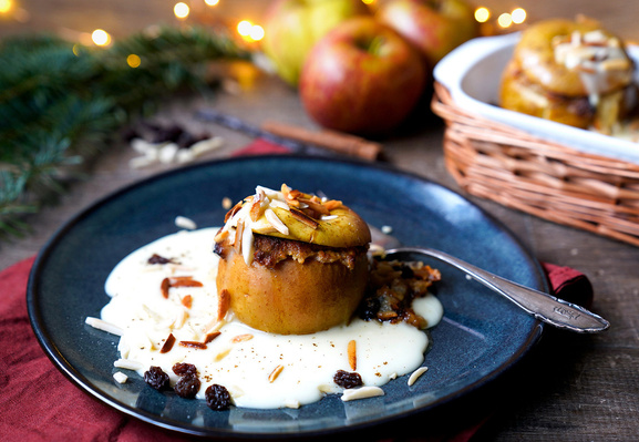 KI generiert: Ein gebackener Apfel auf Vanillesauce, dekoriert mit Mandeln und Rosinen.
