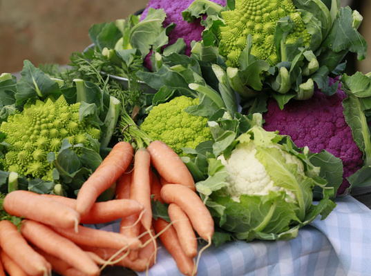 KI generiert: Buntes Gemüse: Verschiedene Blumenkohlarten und Karotten auf einem Tisch.